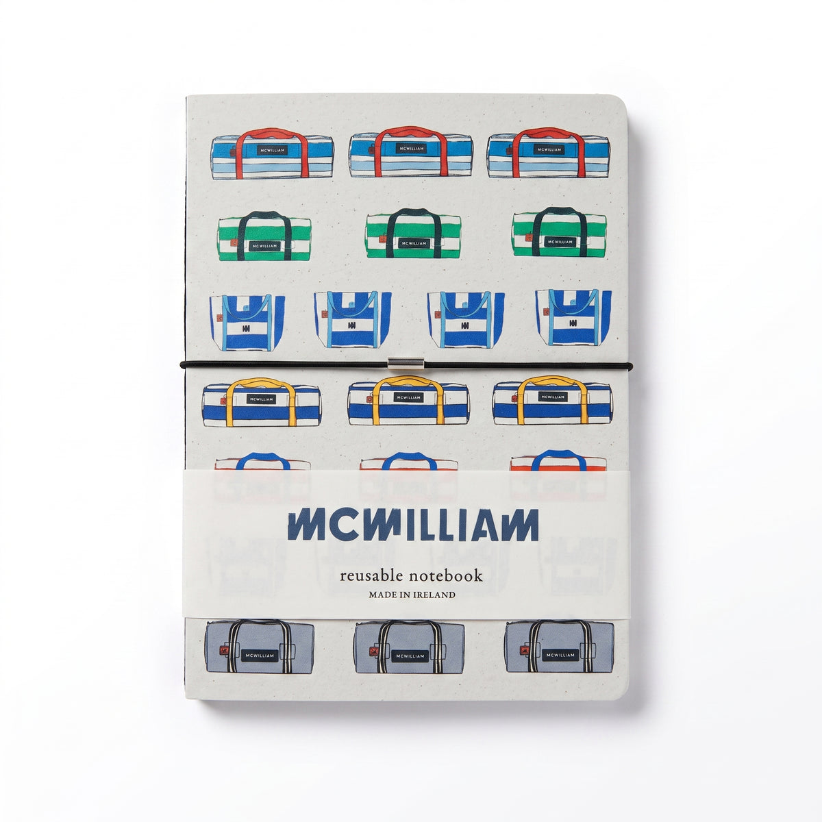A McWillian reusable notebook with a white cover decorated with colorful illustrated duffel bags, secured with a black elastic band and a small metal clasp, on a white background.