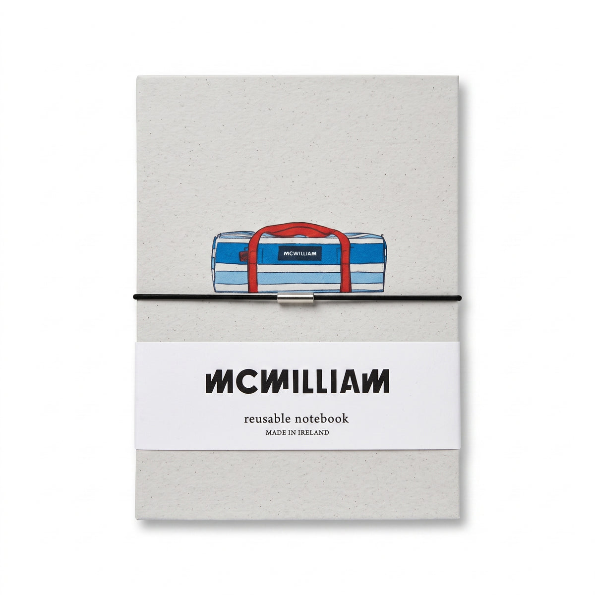 McWilliam reusable notebook with a light gray textured cover, a white paper band with the McMilliam logo, and an illustration of a blue and white striped duffel bag with red handles on the front.